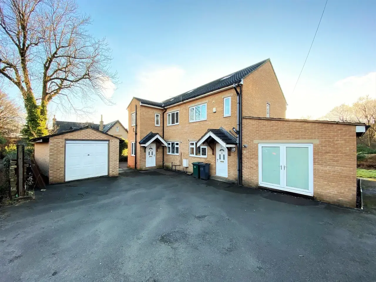 Front exterior and private driveway of Greenhead Road, an eight-bedroom house in Huddersfield