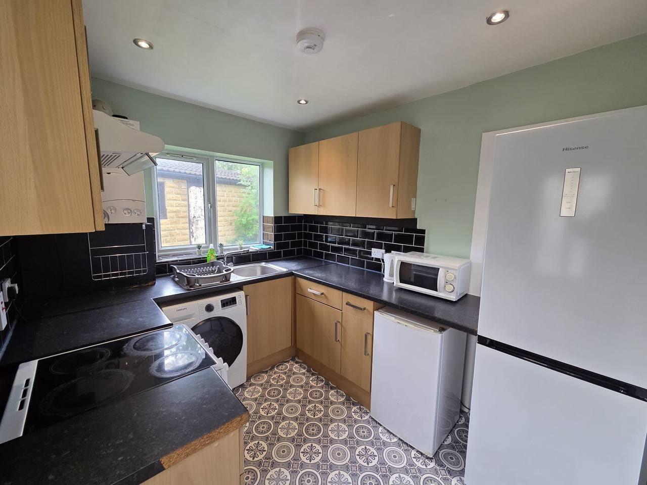 Fitted kitchen with oven, washing machine and tiled splashback — Lynton Avenue 5a, Huddersfield