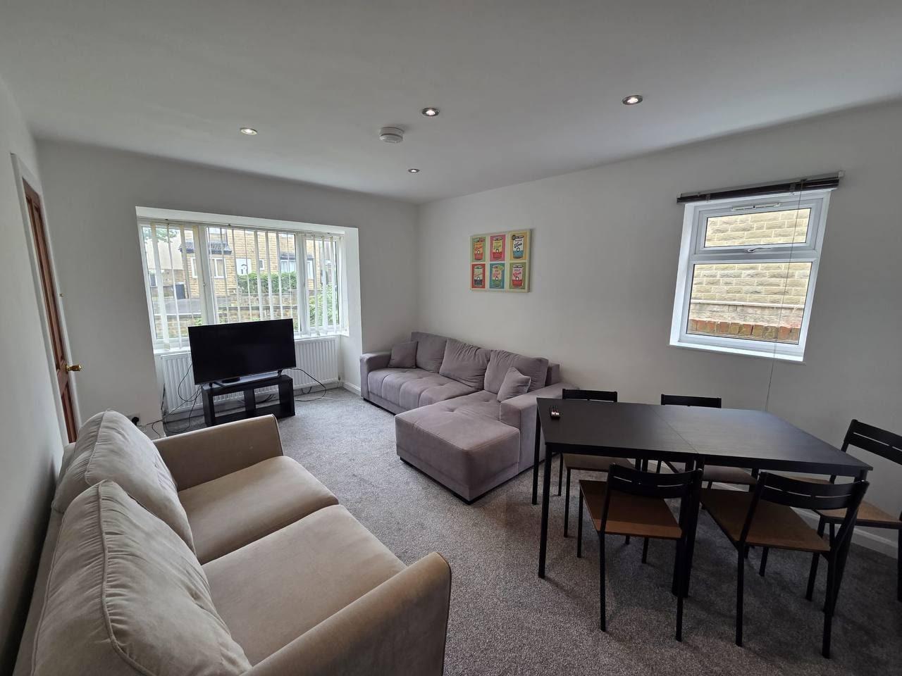 Bright living and dining room with sofas and a six-seat table — Lynton Avenue 10a, Huddersfield