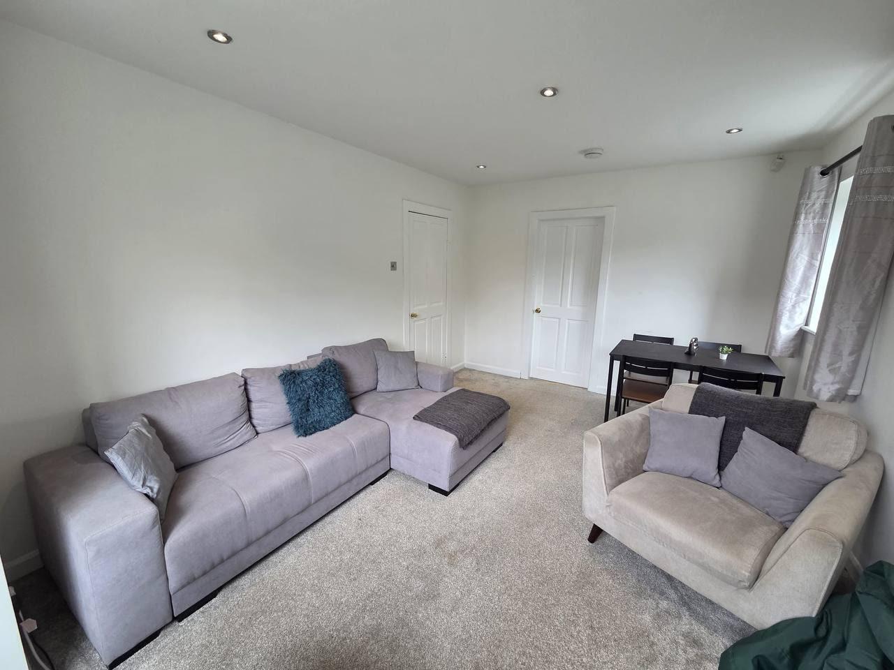 Spacious living room with a corner sofa, armchair and dining table — Lynton Avenue 5a, Huddersfield